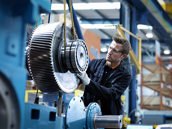 Engineer assembling industrial gearbox in engineering factory