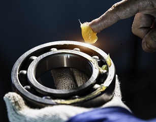 Mechanic is putting yellow grease in the into bearing, engineering and industrial concept., Mechanic is putting yellow grease in the into bearing, engineeri