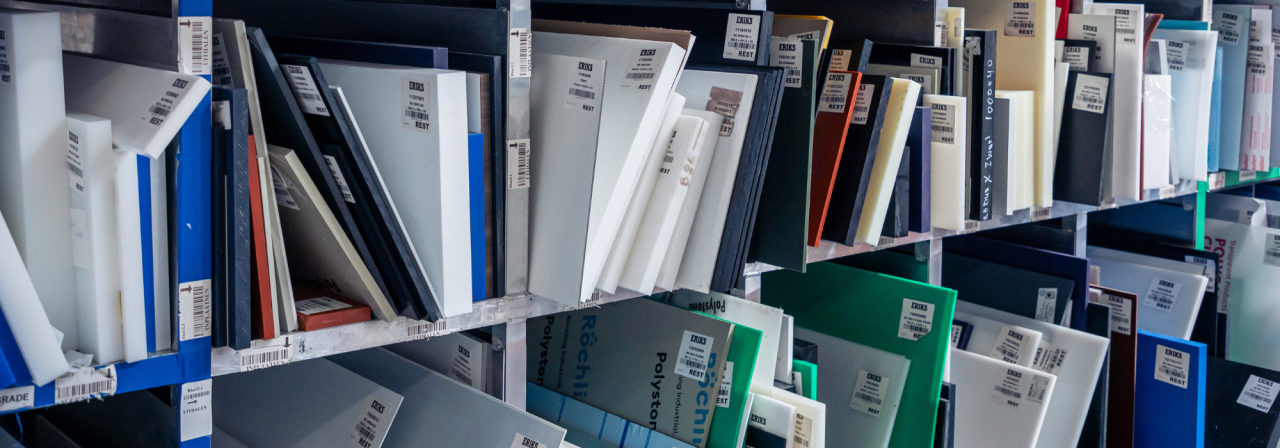 Een close-up van schappen gevuld met netjes georganiseerde plastic monsters in verschillende kleuren en maten, elk voorzien van ERIKS-productlabels.